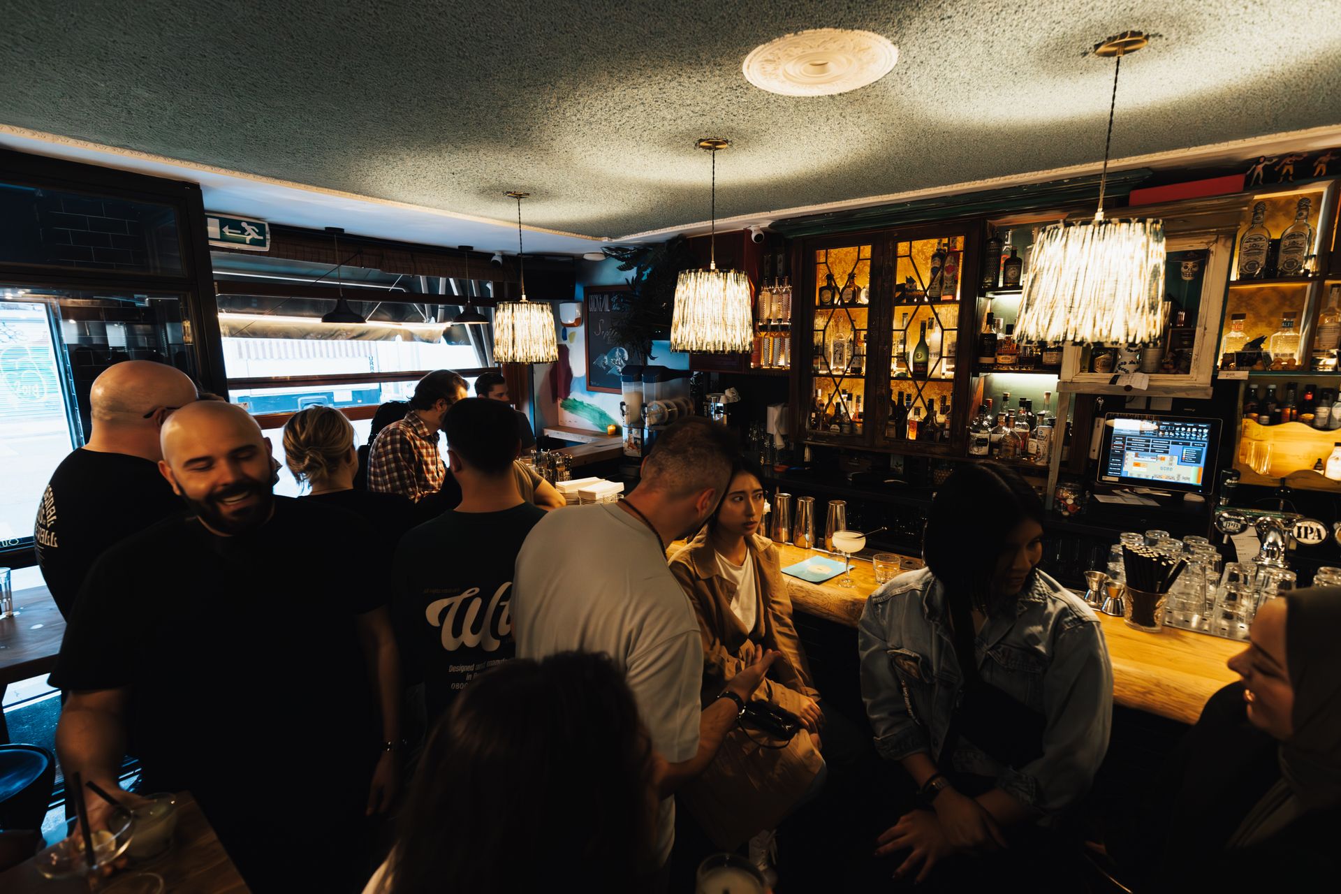 Customers crowded three-deep waiting to be served at a bar