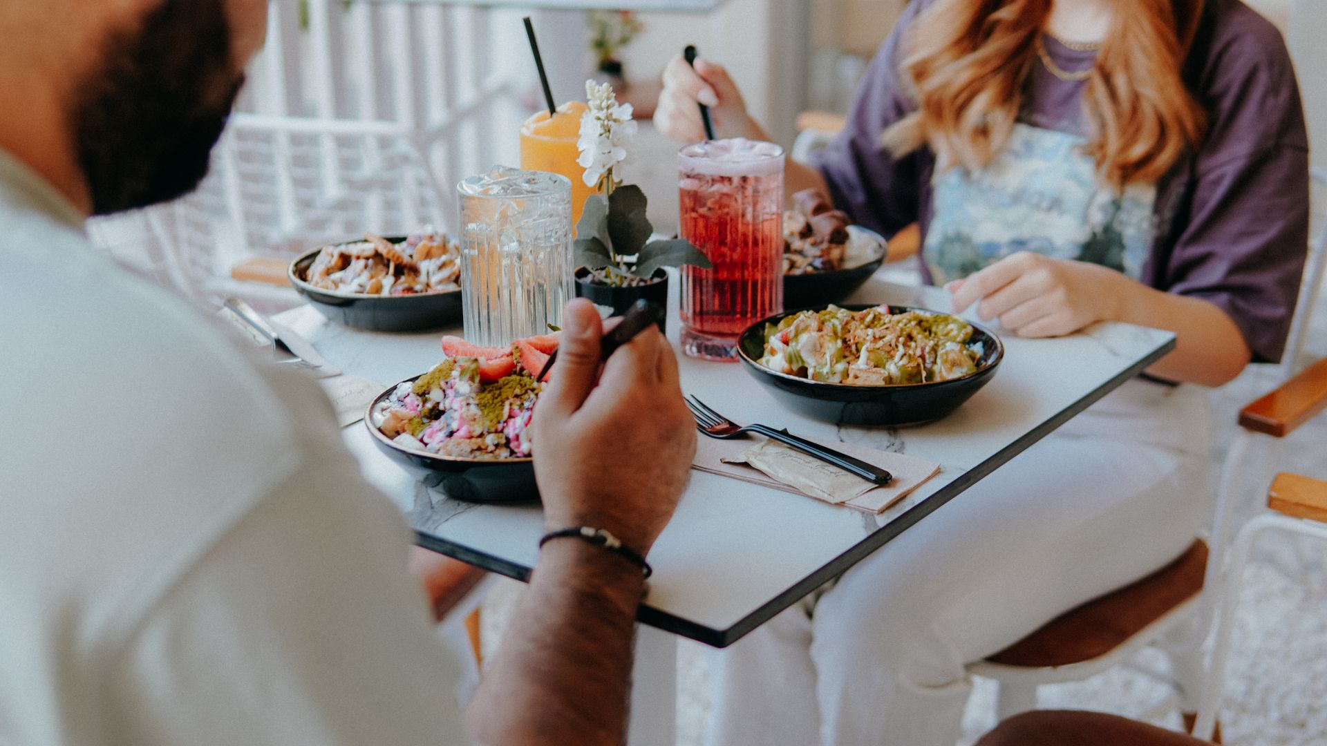 Two friends eating brunch together in a bright café