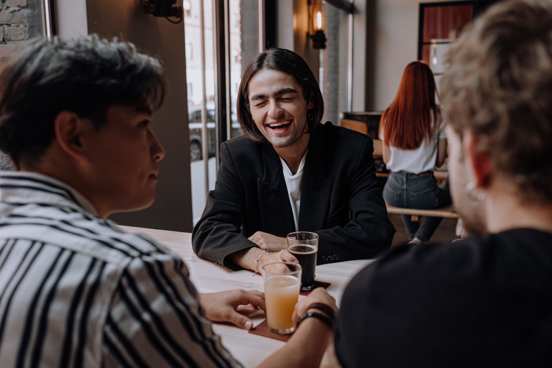 Friends relaxed and laughing over drinks, served without queueing